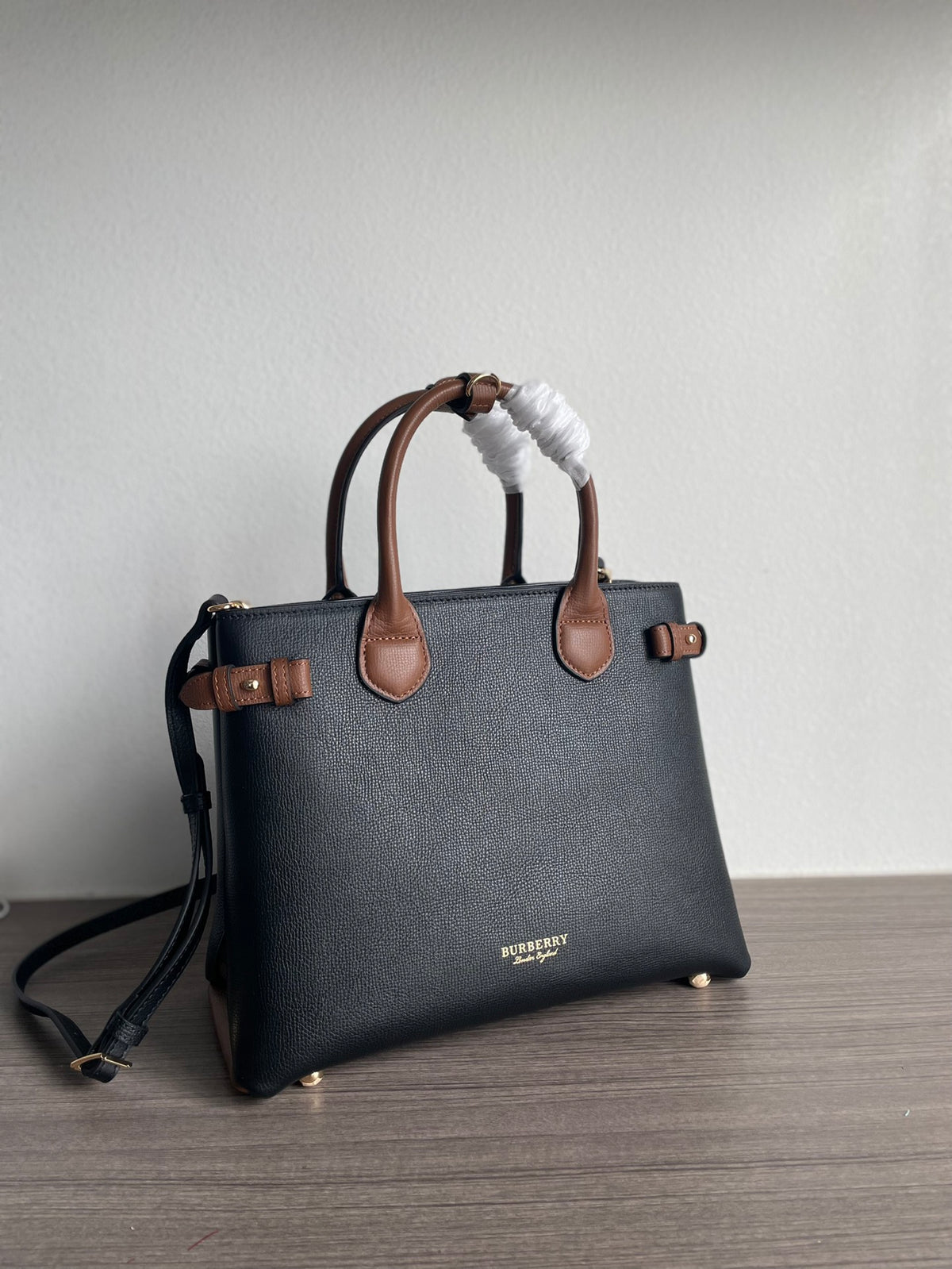 Elegant Black Structured Handbag with Brown Leather-Style Handles