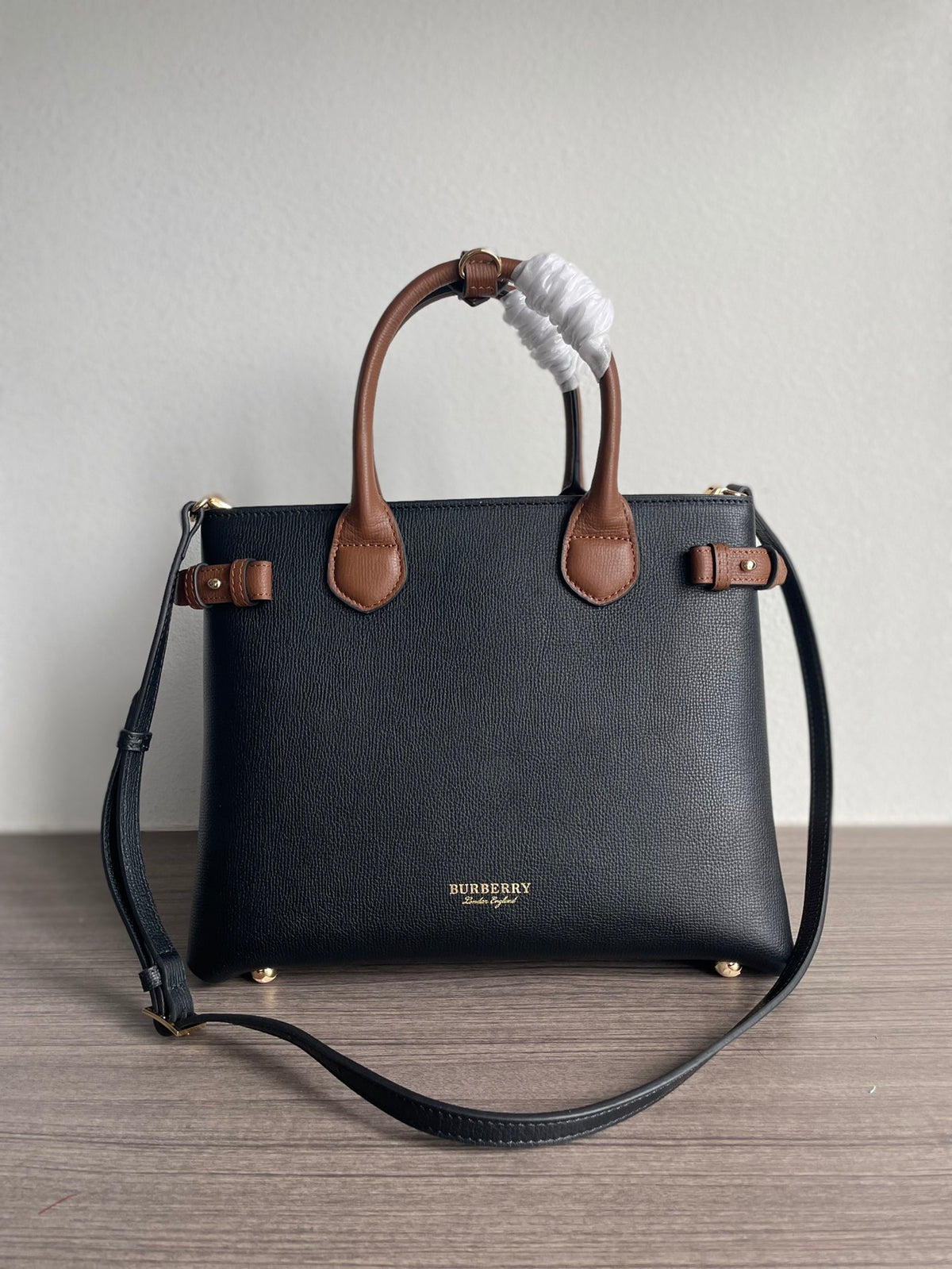 Elegant Black Structured Handbag with Brown Leather-Style Handles