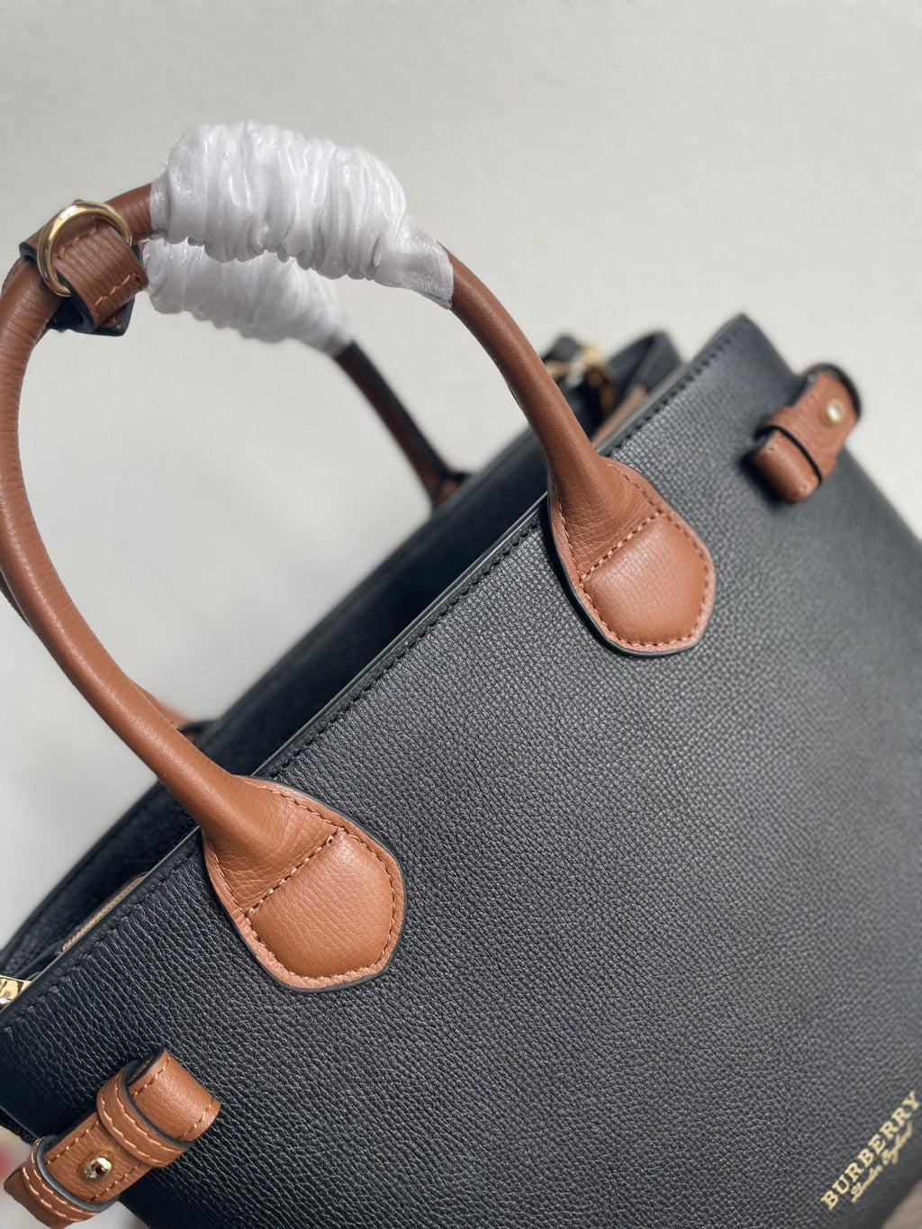 Elegant Black Structured Handbag with Brown Leather-Style Handles