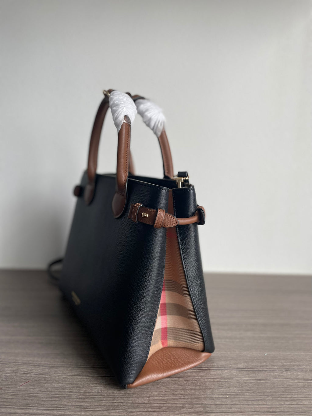 Elegant Black Structured Handbag with Brown Leather-Style Handles