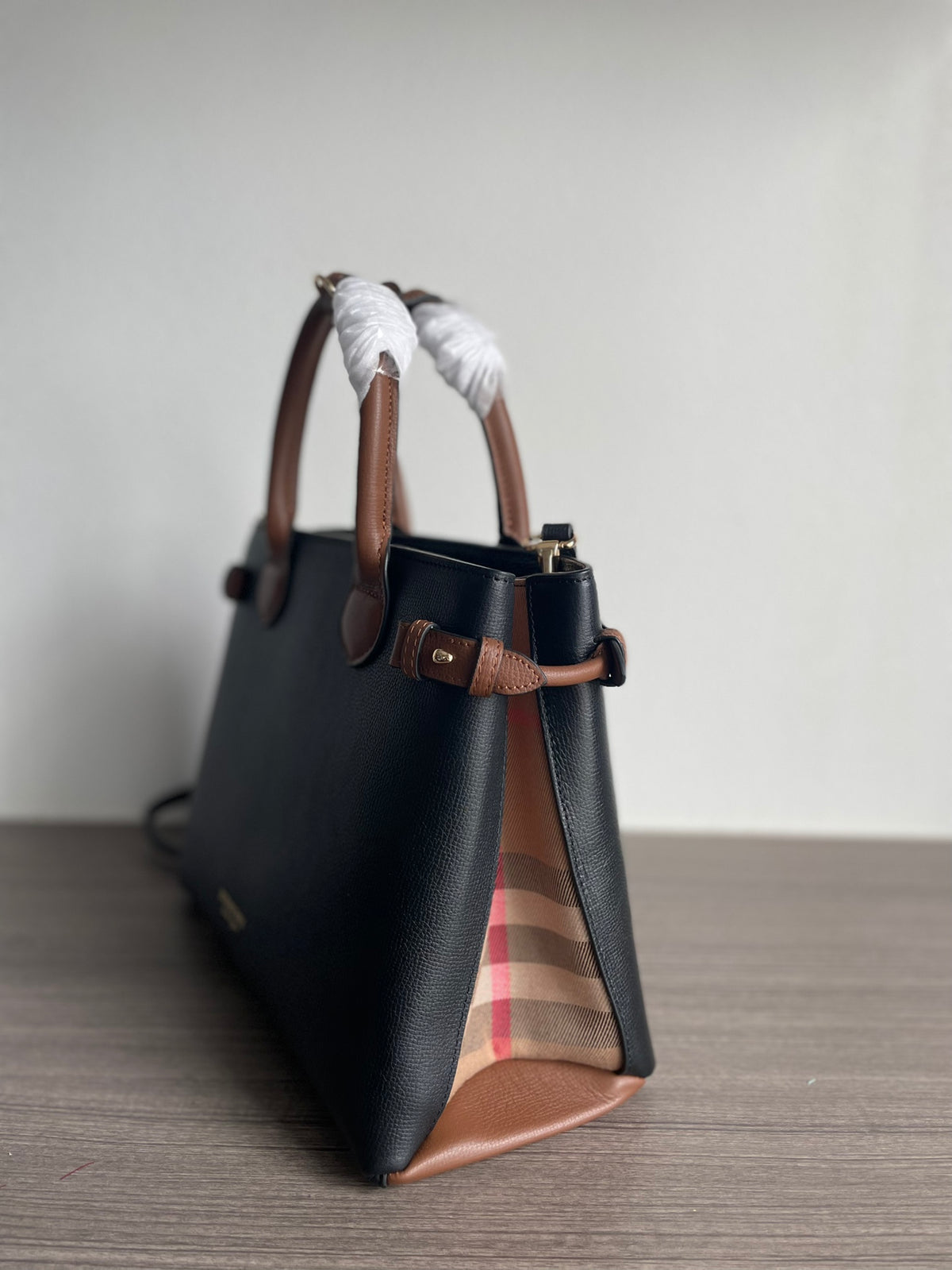 Elegant Black Structured Handbag with Brown Leather-Style Handles